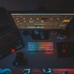 A contemporary workspace featuring dual monitors, a rainbow-lit keyboard, and editing software, perfect for tech enthusiasts.